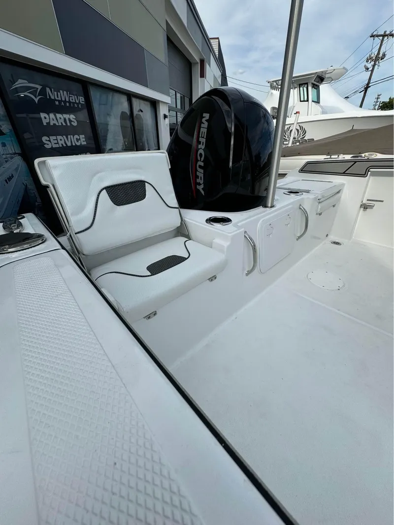 Slide: The Image of 2025 Wellcraft 202 Fisherman boat with Mercury engine, rear seating, and storage compartments. - 2