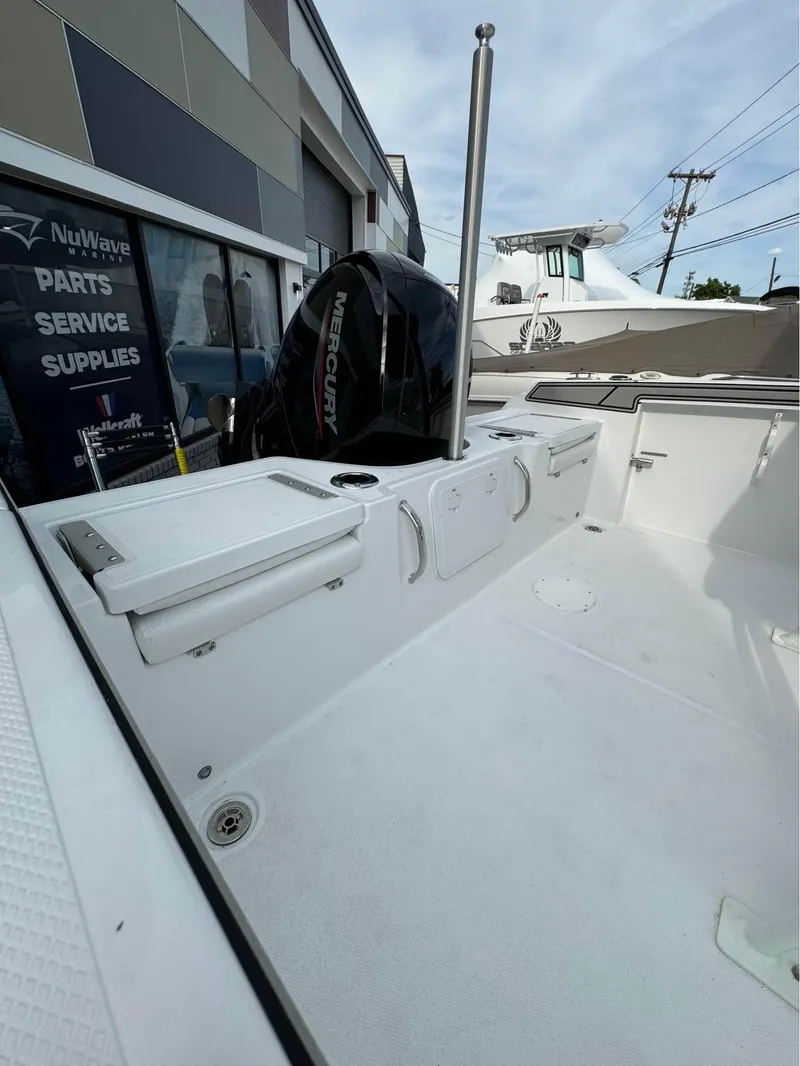 Slide: The Image of 2025 Wellcraft 202 Fisherman boat interior with Mercury outboard motor at a dealership. - 3