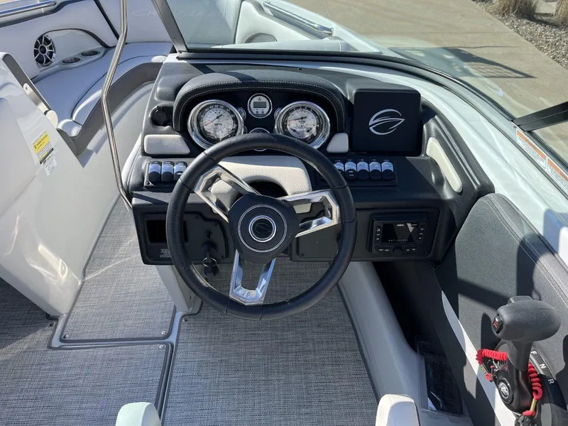 Slide: The Image of 2023 Crownline 210SS boat dashboard with steering wheel and control panel. - 6