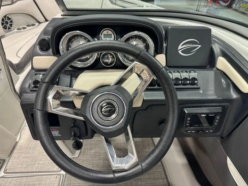 Slide: The Image of 2023 Crownline 210SS boat dashboard with steering wheel and instrument panel. - 7