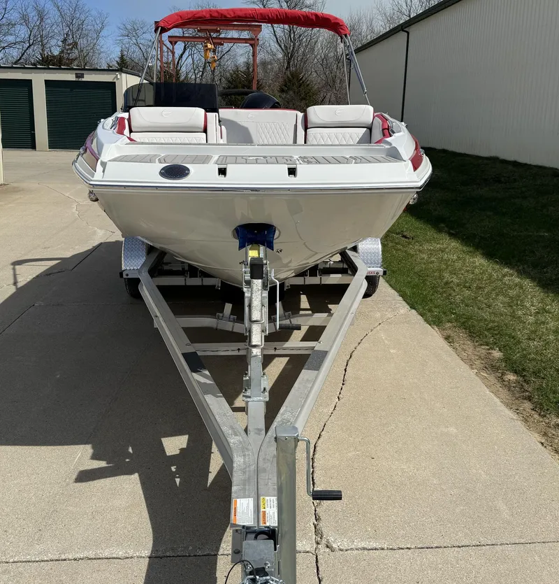 Slide: The Image of 2023 Crownline E205 xs boat on a trailer in a driveway. - 5