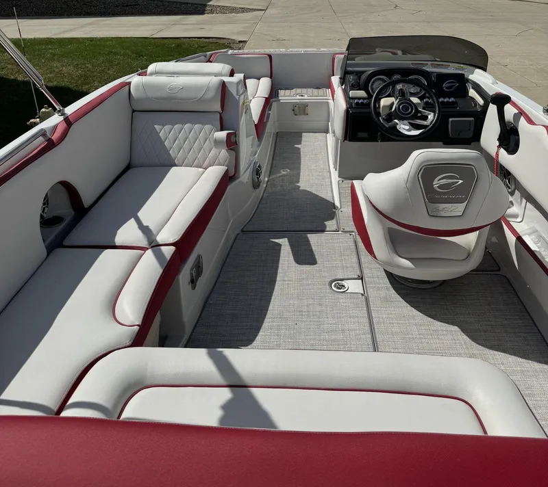 Slide: The Image of 2023 Crownline E205 XS boat interior with white and red seating, modern dashboard. - 9