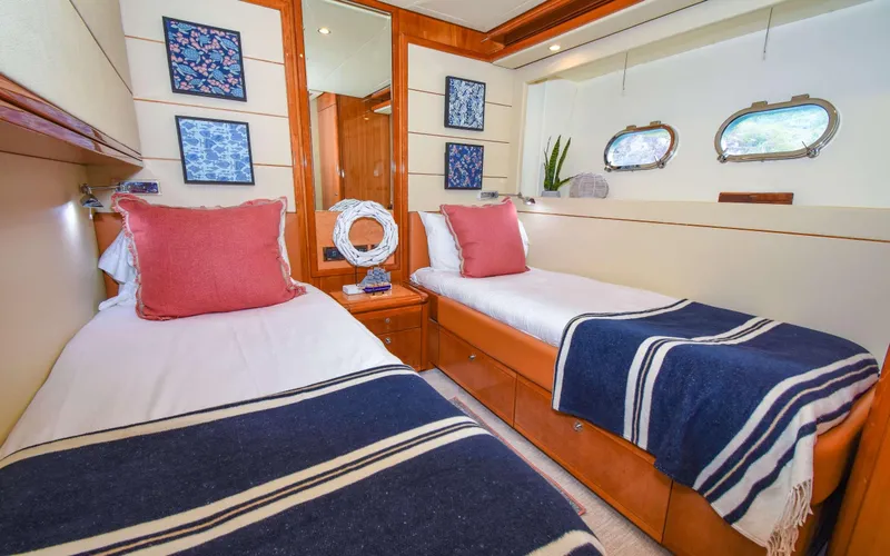 Slide: The Image of Luxurious twin cabin in 2006 Ferretti Yachts 881 with elegant decor and porthole windows. - 12