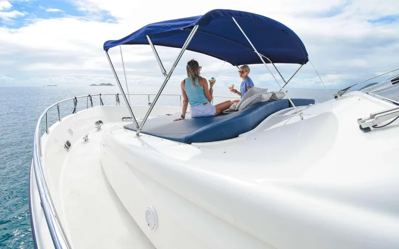 Slide: The Image of Two people relaxing on a 2006 Ferretti Yachts 881 under a blue canopy. - 3