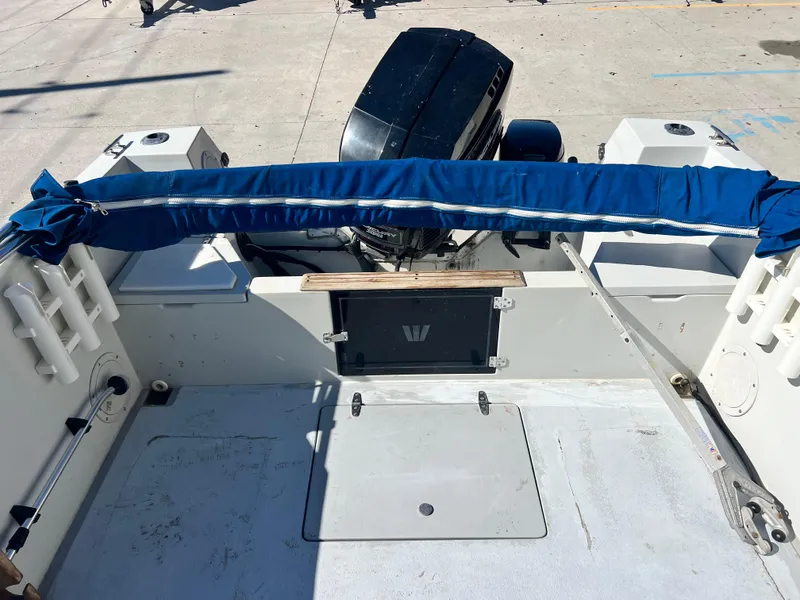 Slide: The Image of 1986 Wellcraft 20 SPORT FISH boat stern with outboard motor and blue cover. - 20