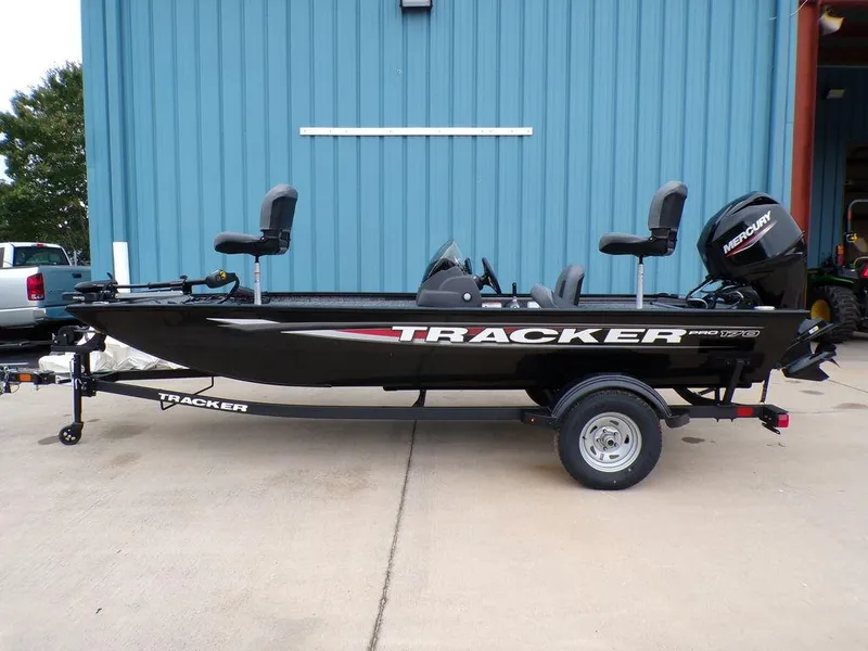 The Image of 2025 Tracker Pro 170 boat on trailer, black exterior, parked by blue building. - 1