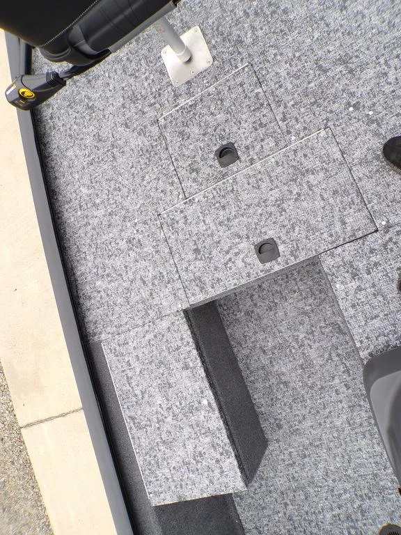 Slide: The Image of 2025 Tracker Pro 170 boat interior with gray carpeted storage compartments. - 12