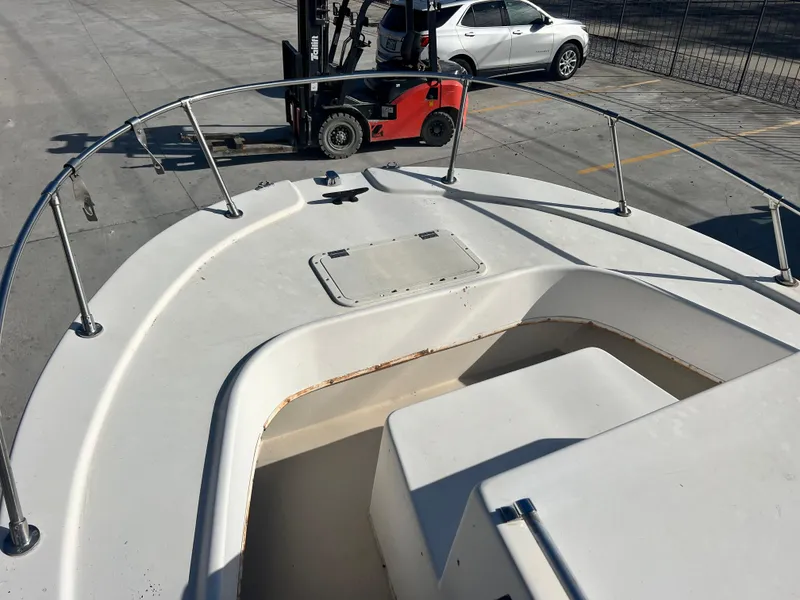 Slide: The Image of 1984 Dusky 233 boat interior with white seating and storage compartments. - 10