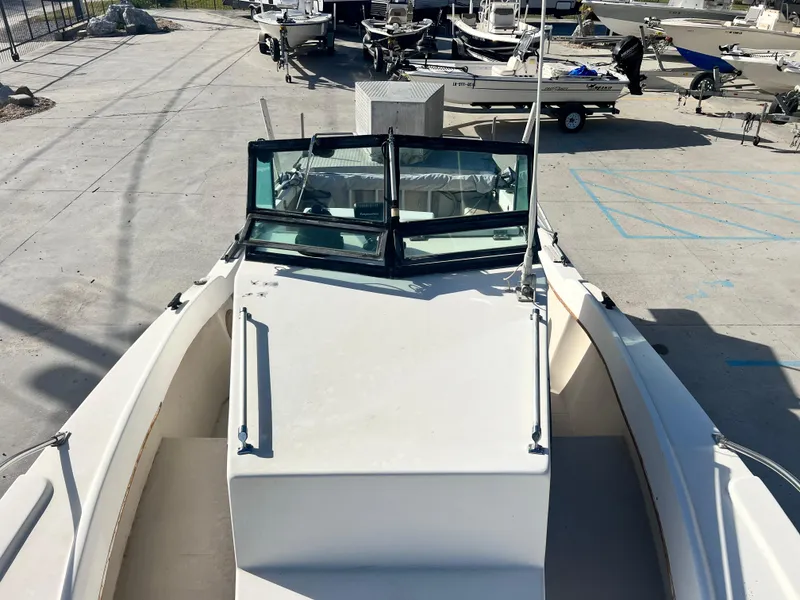 Slide: The Image of 1984 Dusky 233 boat docked at a marina, featuring open windshield and registration number LA4809B. - 12