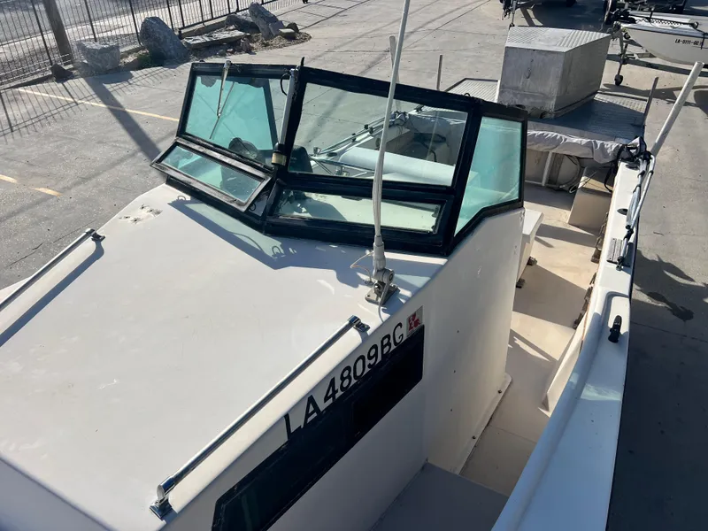 Slide: The Image of 1984 Dusky 233 boat cockpit with steering wheel and control panel. - 14