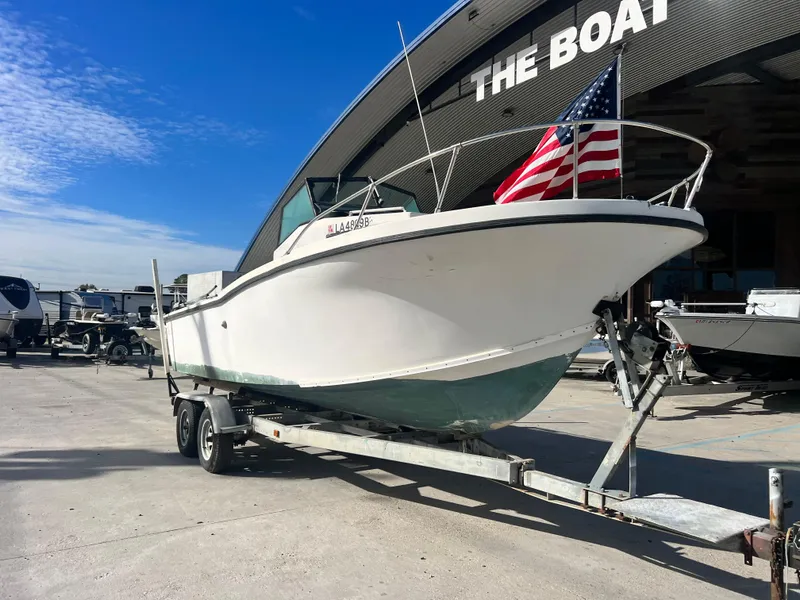 Slide: The Image of 1984 Dusky 233 boat on trailer under clear sky. - 2