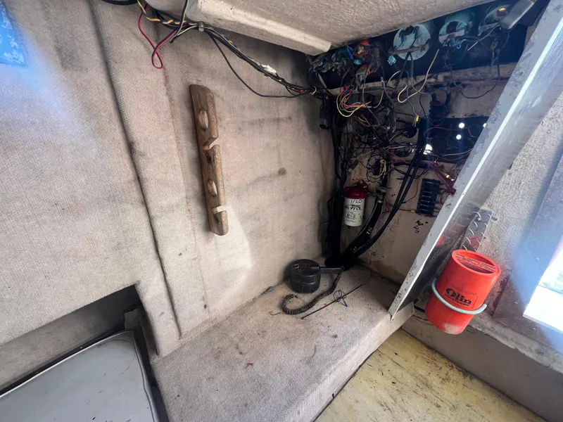 Slide: The Image of Interior of a 1984 Dusky 233 boat showing a fire extinguisher and safety equipment. - 22