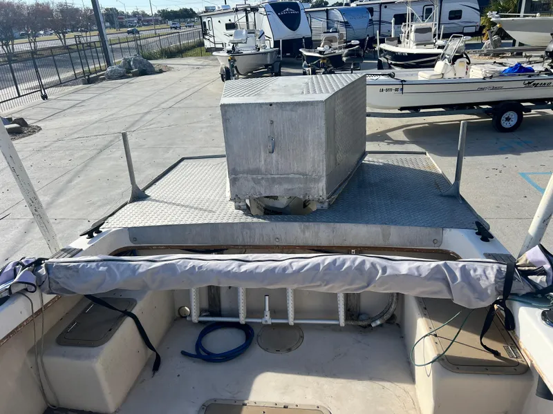 Slide: The Image of 1984 Dusky 233 boat interior with storage compartments and ladder, parked in a marina. - 26