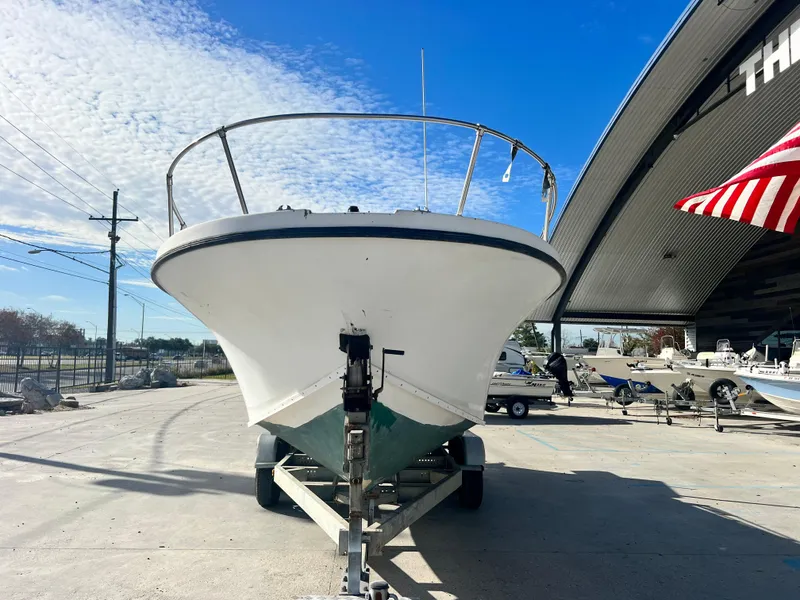Slide: The Image of 1984 Dusky 233 boat on a trailer under a partly cloudy sky. - 3