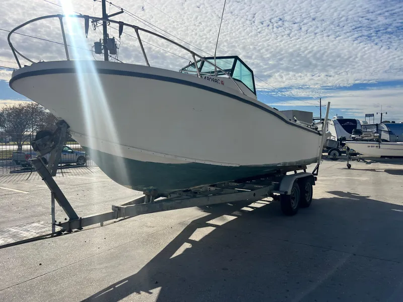 Slide: The Image of 1984 Dusky 233 boat on a trailer in a parking lot. - 4