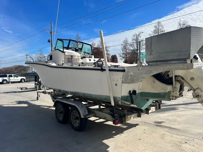 Slide: The Image of 1984 Dusky 233 boat on a trailer, rear view showing outboard motor. - 6