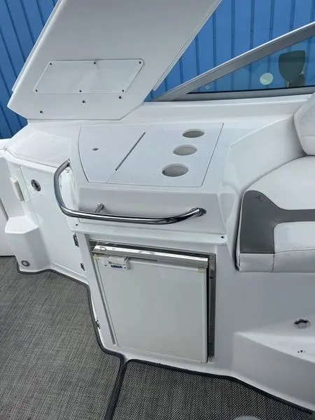Slide: The Image of 2019 Monterey 295SY boat interior with mini fridge and storage compartments. - 13