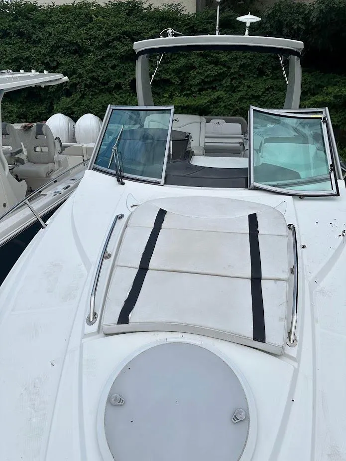 Slide: The Image of 2019 Monterey 295 SY boat with open deck and windshield, docked beside another vessel. - 38