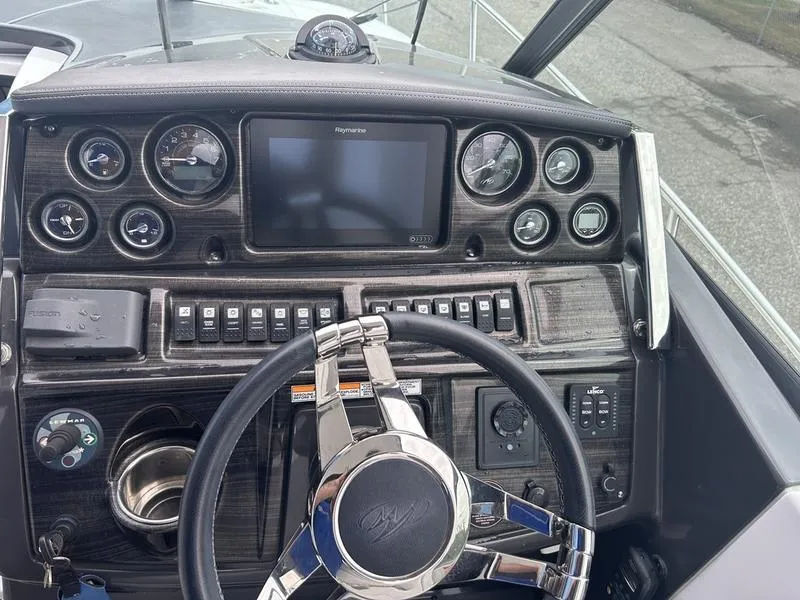 Slide: The Image of Dashboard of a 2019 Monterey 295SY boat with steering wheel and control panel. - 6