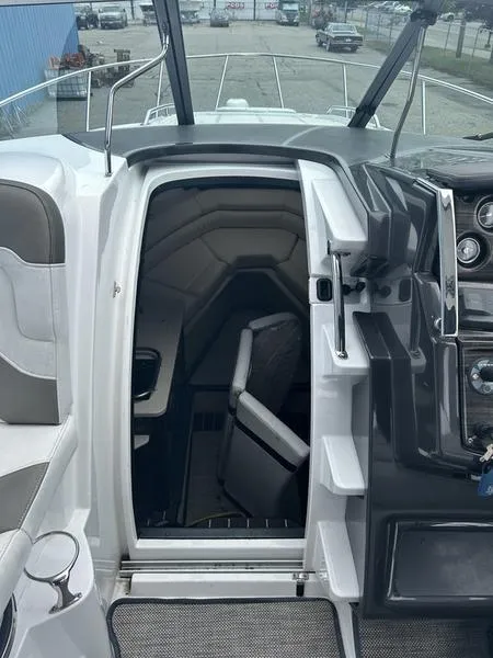 Slide: The Image of 2019 Monterey 295SY boat interior with cabin entrance and cockpit view. - 9