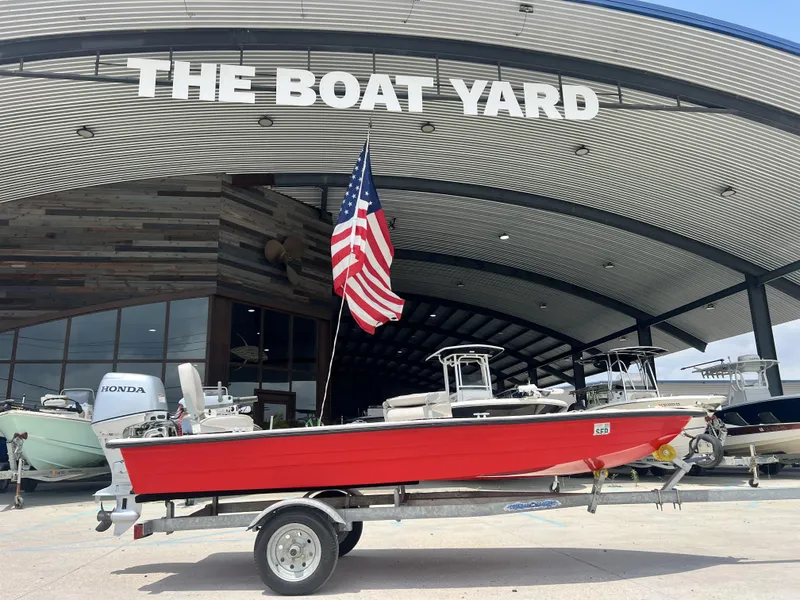 The Image of Red Custom 14 boat (2023) on trailer at The Boat Yard with American flag. - 1