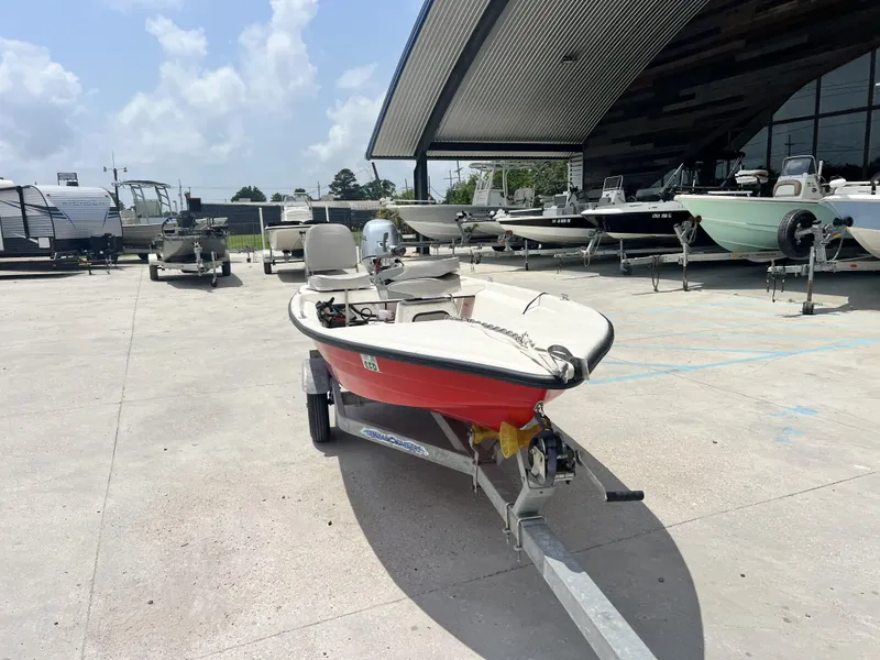 Slide: The Image of Custom 14 boat 2023 model on trailer at dealership, surrounded by various boats. - 12