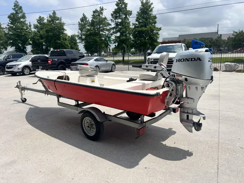 Slide: The Image of Red Custom 14 boat (2023) with Honda outboard motor on trailer. - 13