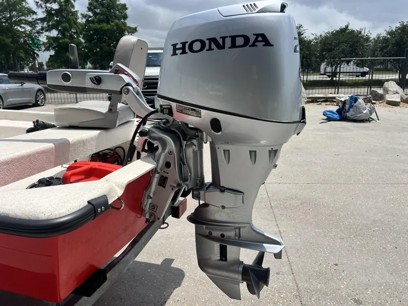 Slide: The Image of Honda outboard motor on a Custom 14 boat, 2023 model, parked outdoors. - 14