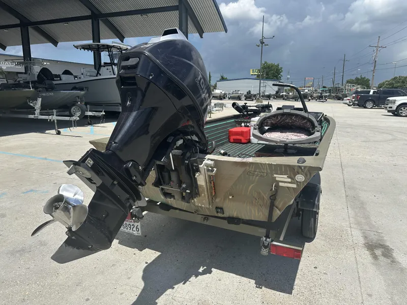 Slide: The Image of 2016 Tracker 1648 boat with outboard motor in a parking lot. - 5