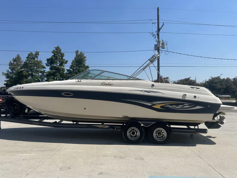 Slide: The Image of 2003 Rinker 282 Captiva boat on a trailer, side view, outdoors. - 4