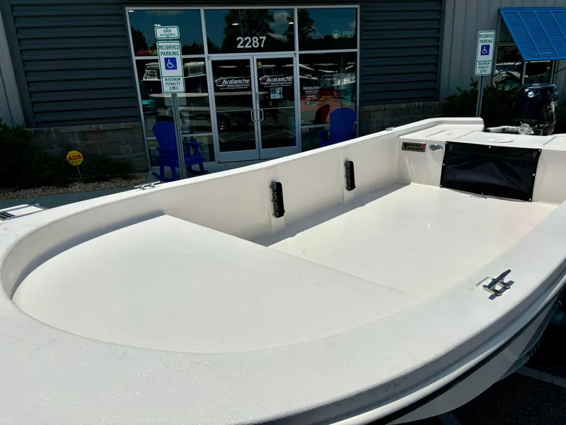 Slide: The Image of 2025 Carolina Skiff EV16 JVX TH boat displayed outside a showroom. - 3