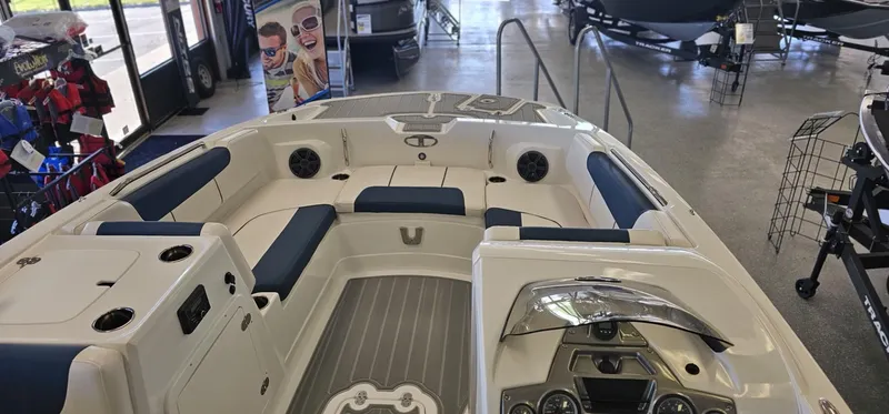 Slide: The Image of 2024 Tahoe 2150 boat interior with blue seating and modern dashboard in showroom. - 2
