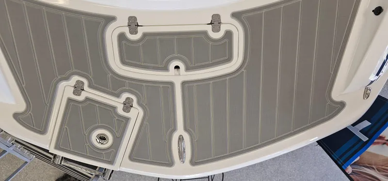 Slide: The Image of 2024 Tahoe 2150 boat deck with gray non-slip surface and storage hatch. - 5