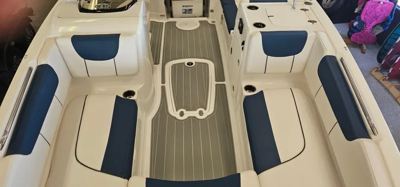 Slide: The Image of 2024 Tahoe 2150 boat interior with white and blue seating, gray flooring. - 6