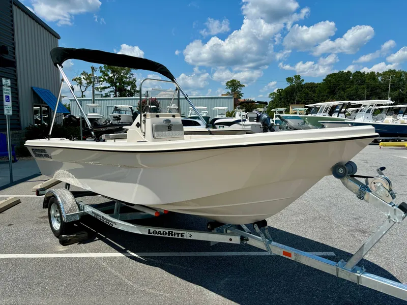 Slide: The Image of 2025 Carolina Skiff 162 JLS boat on trailer, parked outdoors under a blue sky. - 3