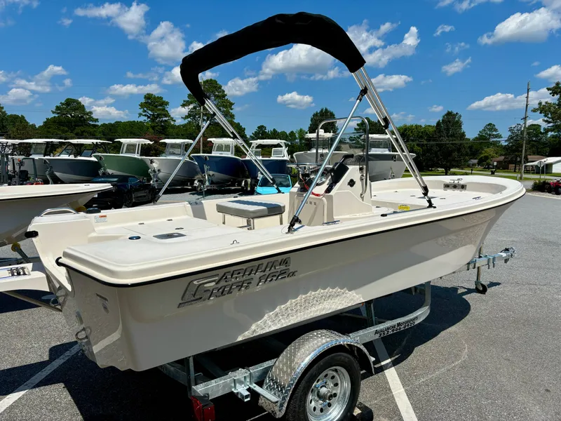 Slide: The Image of 2025 Carolina Skiff 162 JLS boat on trailer under clear blue sky. - 5