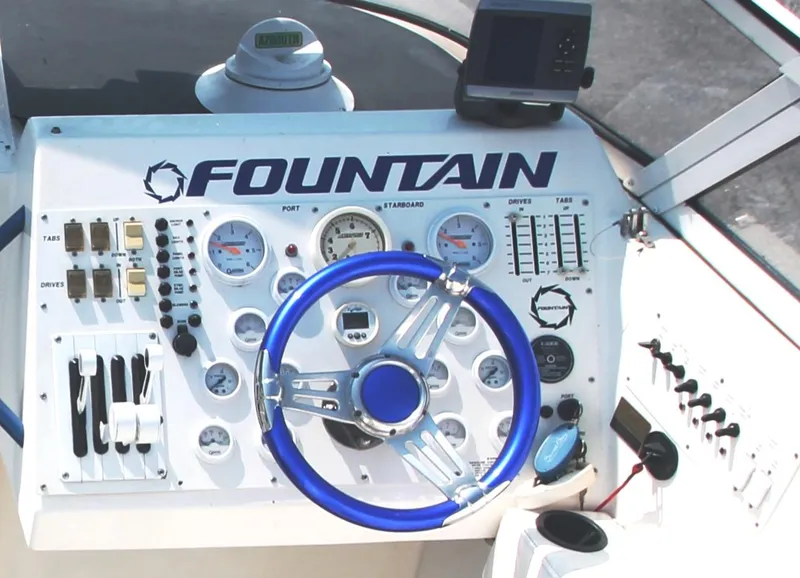Slide: The Image of Control panel of a 1999 Fountain 42 Staggered boat with blue steering wheel. - 12