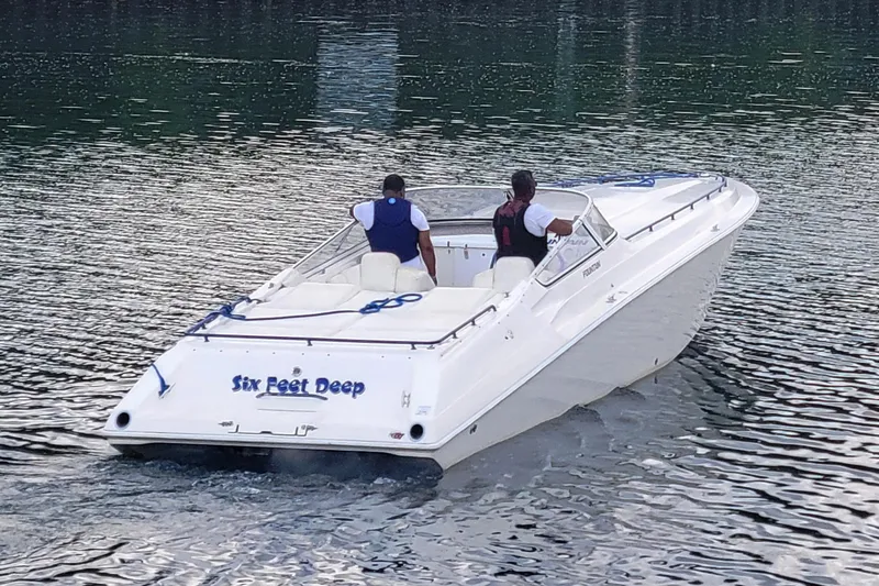 Slide: The Image of 1999 Fountain 42 Staggered speedboat on water, two people onboard, named "Six Feet Deep". - 4
