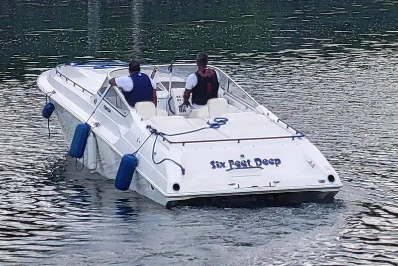Slide: The Image of 1999 Fountain 42 Staggered boat on water, two people onboard, named "Six Feet Deep." - 5