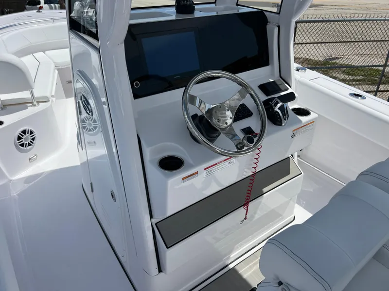 Slide: The Image of 2024 Sportsman Open 232 Center Console boat helm with modern controls and steering wheel. - 7