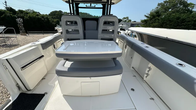 Slide: The Image of 2025 Boston Whaler 330 Outrage boat interior with seating and table, showcasing modern design. - 12