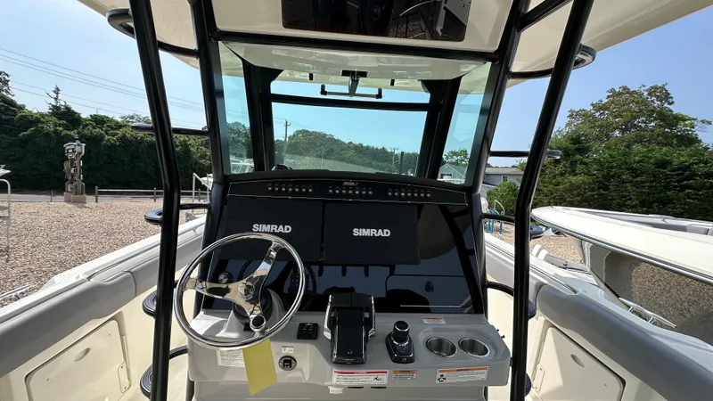 Slide: The Image of 2025 Boston Whaler 330 Outrage helm with Simrad electronics and steering wheel. - 13