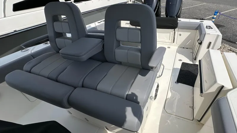 Slide: The Image of 2025 Boston Whaler 330 Outrage boat seating area with gray cushioned seats. - 17