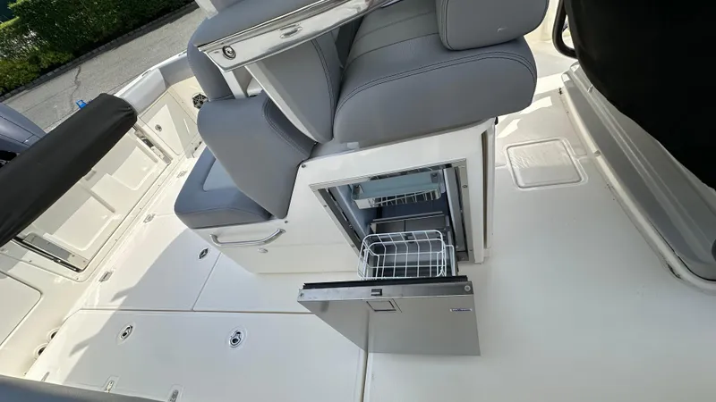 Slide: The Image of 2025 Boston Whaler 330 Outrage interior with open storage compartment and seating. - 21