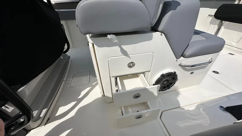 Slide: The Image of 2025 Boston Whaler 330 Outrage interior with storage drawers and seating. - 22