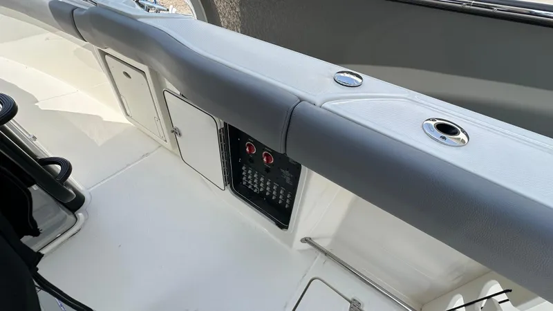 Slide: The Image of 2025 Boston Whaler 330 Outrage boat interior with control panel and storage compartments. - 23