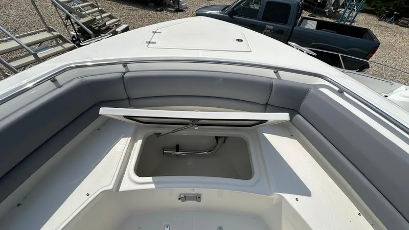 Slide: The Image of 2025 Boston Whaler 330 Outrage boat with open storage compartment and cushioned seating. - 32