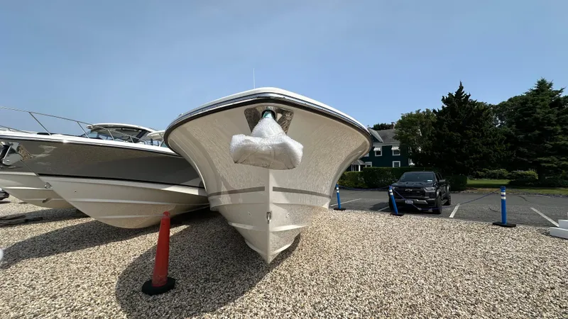 Slide: The Image of 2025 Boston Whaler 330 Outrage boat on display in a parking area. - 37