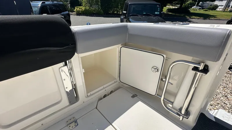 Slide: The Image of 2025 Boston Whaler 330 Outrage boat interior storage compartment and seating area. - 4