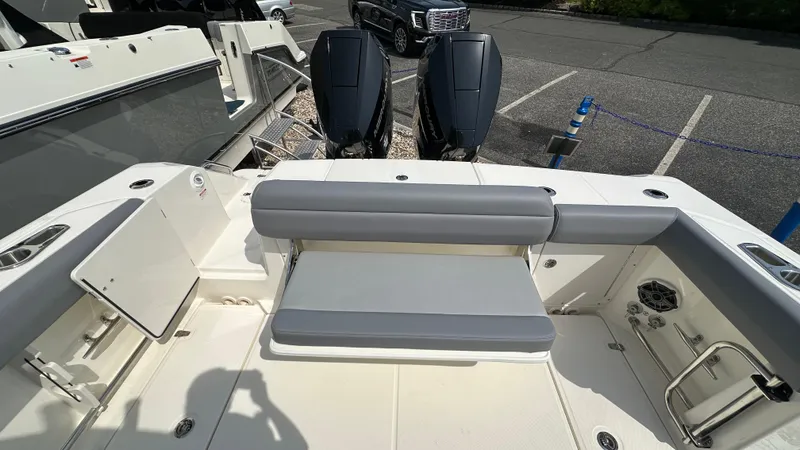 Slide: The Image of 2025 Boston Whaler 330 Outrage boat interior with seating and dual outboard engines. - 6